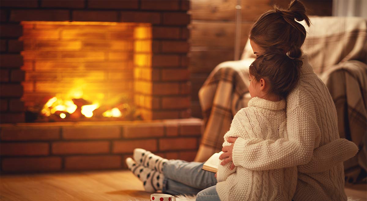 mother and daughter in front of a fire place